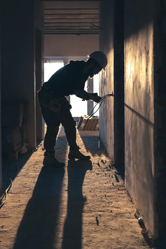 Artisan charpentier  en train d’effectuer des travaux à l’intérieur d’un logement en rénovation